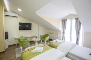 a hotel room with two beds and a tv at Apartmani MG in Nikšić