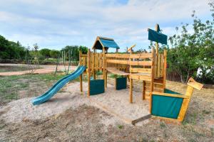 a wooden playground with a slide at Masia Cal Ros in S'Agaro
