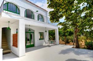 an external view of a white house with green accents at Masia Cal Ros in S'Agaro