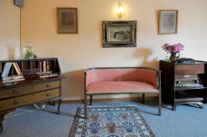 a living room with a chair and a dresser at Hotel Restaurant La Ferme de Grambais in Nivelles