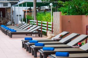 a row of benches with blue cushions on a patio at The Privacy Beach Resort & Spa in Sam Roi Yot