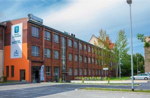 un edificio de ladrillo rojo con un cartel delante en H24 Berlin Lichtenberg en Berlín