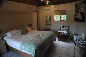 sypialnia z dużym łóżkiem i krzesłem w obiekcie Roundhouse Guesthouse w mieście Franschhoek