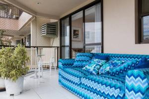 um sofá azul sentado numa sala de estar em Delicioso Apartamento com Linda Vista no Rio de Janeiro