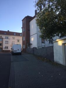 a white van parked on a street next to buildings at Gästewohnung in Pirmasens