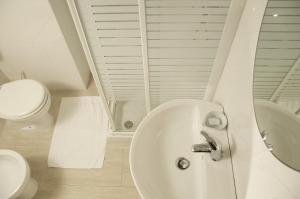 ein weißes Badezimmer mit Waschbecken und Toilette in der Unterkunft Residence Castello in Santa Cesarea Terme + 28 Fotos