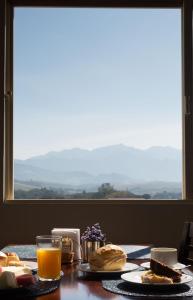 a table with food and a glass of orange juice at Hotel Embaixador in Cruzeiro