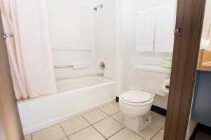 a bathroom with a white toilet and a tub and a sink at Morada Inn in Anaheim