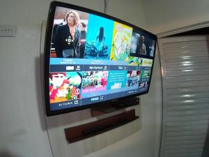 una TV a schermo piatto appesa a una parete di Hotel Talu ad Angatuba