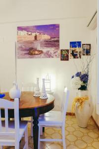 a dining room with a wooden table and white chairs at Dimora Storica Monopoli in Monopoli +69 photos