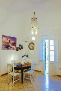 a dining room with a table and chairs and a clock at Dimora Storica Monopoli in Monopoli