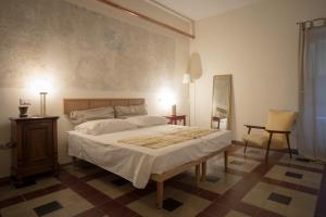 ein Schlafzimmer mit einem Bett, einem Tisch und einem Stuhl in der Unterkunft Piazza San Pantaleo in Sorso