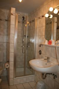 ein Bad mit einer Dusche und einem Waschbecken in der Unterkunft Albertus Paris Aparthotel in Hamburg