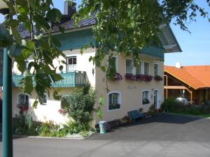 a white house with flowers on the windows at Appartement "Haus Lisa" in Ramsau am Dachstein in Ramsau am Dachstein