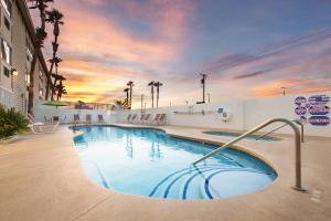 a large swimming pool with a sunset in the background at Arizona Charlie's Decatur in Las Vegas