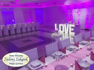 a purple room with a table with a sign that says love at Dom Weselny Zielony Zakątek in Jarocin