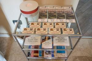 una mesa de cristal con libros y panfletos. en B&B Borfuro, en Bérgamo