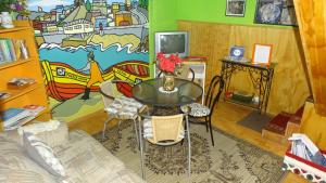 a table and chairs in a room with a mural at Hostal Destino Bellavista in Valparaíso