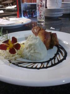 a white plate with food on a table at Ville de Montagne Hotel in Brumadinho