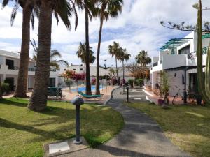 a park with palm trees and a sidewalk at Departamento Joelle in Puerto del Carmen
