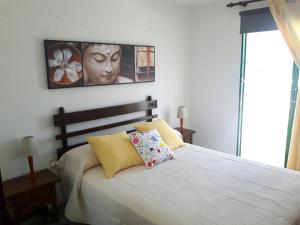 Caleta de CaballoにあるCaleta Caballo Beachのベッドルーム1室(ベッド1台付)が備わります。壁に絵が飾られています。