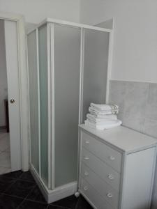 uma casa de banho com um armário e uma pilha de toalhas em Appartamento Ormeni em Cardano al Campo