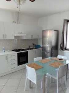 a kitchen with a blue table and a refrigerator at Appartamento Ormeni in Cardano al Campo