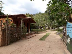 un edificio con una valla al lado de un camino de tierra en Casa da Trilha, en Vale do Capao