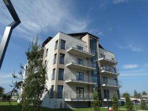 an apartment building with balconies and a blue sky at Apartament z widokiem na morze - Apartament Turkusowy in Sianozety