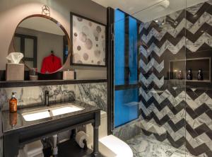 
a bathroom with a sink, mirror, and bathtub at The Wild Oscar in Mexico City
