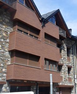 a building with a wooden facade with windows at Apartament Esterri Centre in Esterri d'Àneu