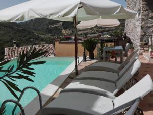 a row of chairs and an umbrella next to a swimming pool at B&B Il Belvedere in Guardialfiera