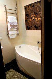La salle de bains est pourvue d'une baignoire blanche et de serviettes. dans l'établissement Hotel Meduza, à Kharkov