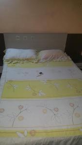 a bed with a flower patterned blanket on it at Habitación en casa zona Asunción in Asunción