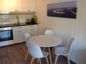 uma cozinha com uma mesa e cadeiras e um lavatório em Appart & p'tit Jardin em Arès