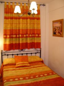 アロヨ・フリオにあるCasa Antoniaのベッドルーム1室(オレンジ色のカーテン付きのベッド1台付)