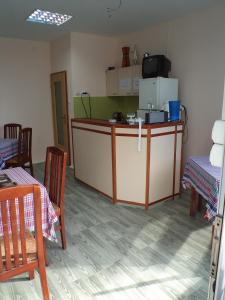 Motel Le Village في إسكوبية: مطبخ مع كونتر مع كراسي وثلاجة