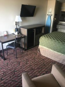 a hotel room with a bed and a desk and a desk at Americas Best Value Inn West Monroe in West Monroe