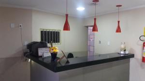 a kitchen with a counter with flowers and pendant lights at Hotel Hawai in Ceilândia