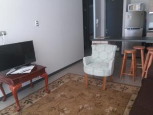 sala de estar con escritorio, silla y TV en Bahia horizonte herradura, en Coquimbo