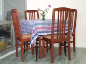 a dining room table with three chairs and a table cloth at Motel Le Village in Skopje
