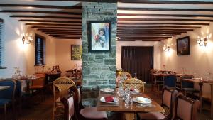 a restaurant with tables and chairs and a stone wall at New Gurkha Inn in Talgarth