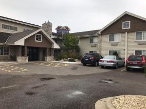 a parking lot with cars parked in front of a building at AmericInn by Wyndham Hotel and Suites Long Lake in Long Lake