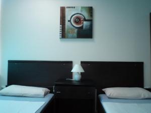 una camera con due letti e una foto a parete di Motel Le Village a Skopje