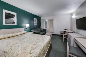 a hotel room with a large bed and a television at Heritage Inn Hotel & Convention Centre - Taber in Taber