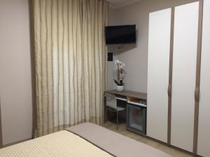 a hotel room with a desk and a television at Villa Augustea in Somma Vesuviana