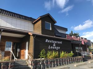 restauracja i budynek z tabliczką, która czyta restaurację i salon w obiekcie Shelikof Lodge w Kodiak