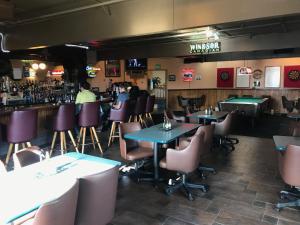 a restaurant with tables and chairs and a bar at Shelikof Lodge in Kodiak