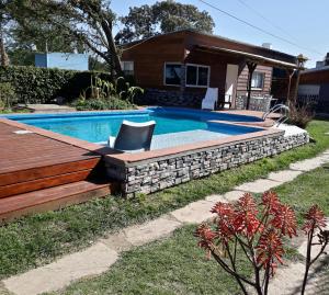 una piscina en un patio con una casa en Cabaña Santa Rita del lago, Villa Carlos Paz, pileta privada, en exquisito barrio residencial, dos cuadras lago y costanera nueva en Villa Carlos Paz