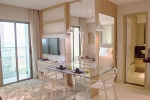 una camera con un tavolo in vetro, sedie e un letto di Premium Flat Ponta Negra Natal a Natal